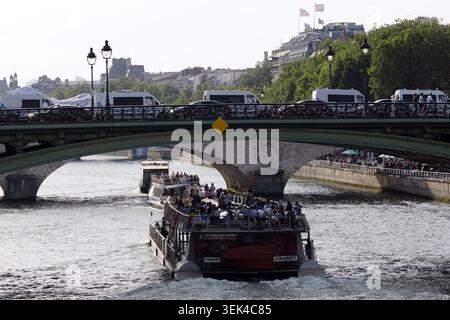Sightseeing boat cruises along the River Seine beneath Paris bridges. Stock Photo