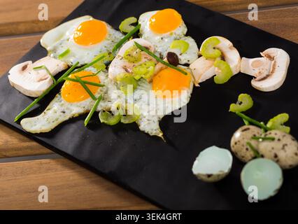 Fried quail eggs with champignons Stock Photo