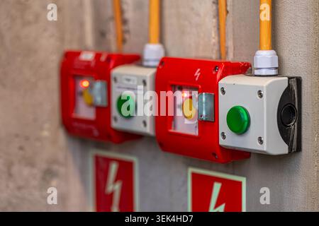 Red emergency stop buttons on the wall. Safety devices connected to the electrical network. Stock Photo