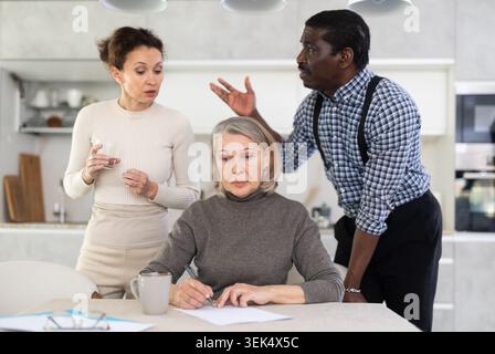Couple discussing testament with elderly woman Stock Photo