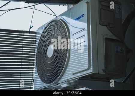 Balikpapan, Indonesia - May 9 2026. An external air conditioning compressor unit installed outdoors, showing the fan grill, and housing. Stock Photo