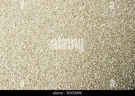 Close up macro shot showing rough texture of light brown sand grains forming natural seamless background pattern conveying feeling of calm and peacefu Stock Photo