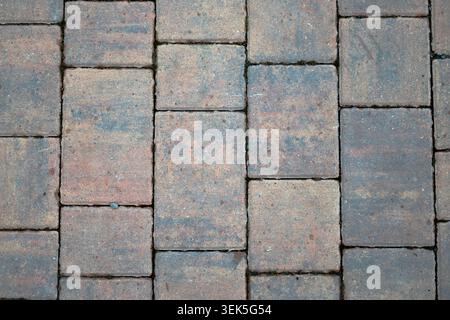 Top down view of weathered rectangular patio pavers with a textured, multi-color stone finish Stock Photo