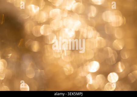 Abstract golden bokeh background with soft shimmering light circles and warm glowing tones. Stock Photo