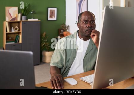 Black Senior Man Learning Online at Home for Career Development Stock Photo