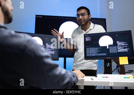 Indian Coding Instructor Teaching AI Programming Lesson To Student In Tech Office Stock Photo