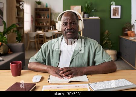 Portrait of Senior Black Man Learning Online at Home Office Stock Photo