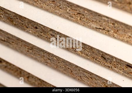 Chipboard in a stack, raw edges of chipboard with coarse wood chips and a porous organic structure of the building material with clear details on a wh Stock Photo
