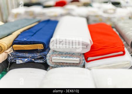 Colorful folded fabric and textile materials displayed in home improvement store Stock Photo