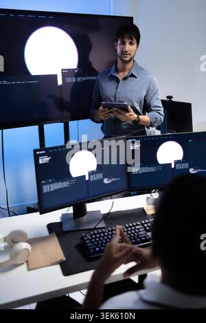 Vertical View Of Programming Instructor Teaching AI Training Lesson In Tech Office Stock Photo
