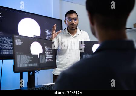 Indian Coding Instructor Teaching AI Programming Lesson To Student In Tech Office Stock Photo