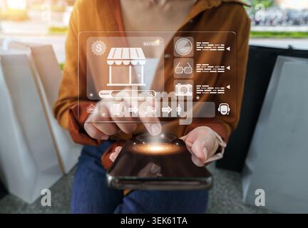 Woman using smartphone with holographic shopping interface for online retail Stock Photo
