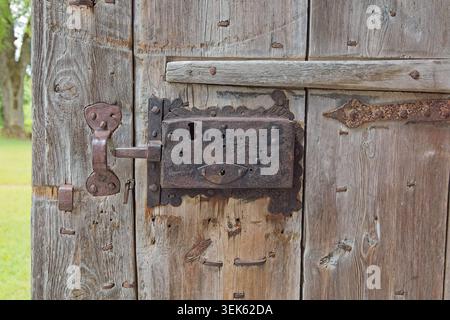 Vintage wrought iron door lock mounted on an weathered wooden door, Saaremaa, Estonia, Europe. Stock Photo