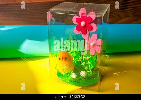 Cute felt chick figurine with flowers and eggs in a clear box Stock Photo
