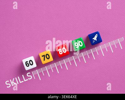 Skills represented by numbered cubes progressing along a ruler towards a rocket icon on a purple background Stock Photo