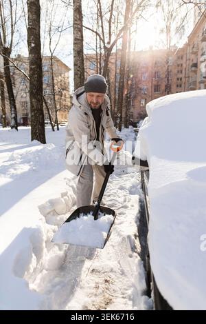 Man shoveling deep snow from his car Stock Photo