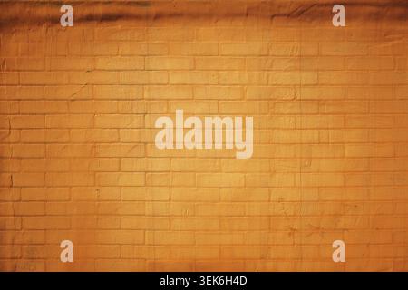 Texture of a brick wall coated in rich burnt-orange paint, showing fine mortar lines and subtle brush strokes as background Stock Photo