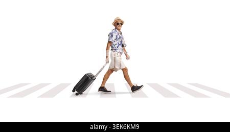 Elderly tourist with a suitcase walking over zebra crossing isolated on white background Stock Photo