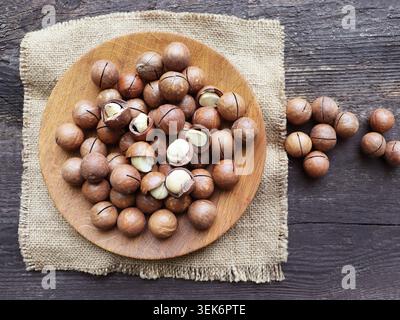 Macadamia nuts on a wooden plate with burlap Stock Photo