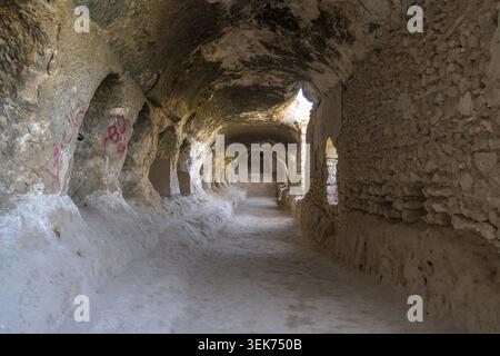 Ancient rock-cut corridors showcasing a historic buddhist cave monastery in aybak Stock Photo