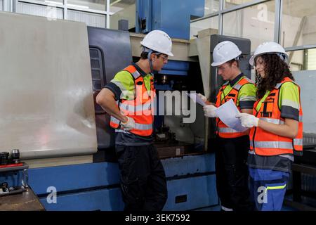 senior engineer and technician team working with industrial machinery in manufacturing. education technician student training and discussing robot pro Stock Photo
