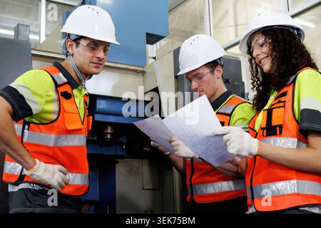 senior engineer and technician team working with industrial machinery in manufacturing. education technician student training and discussing robot pro Stock Photo