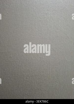 The scene shows a textured silver gray background featuring fine vertical lines. The metallic surface reflects light and can be used for various creat Stock Photo