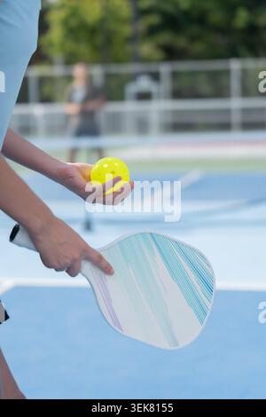 Active Diverse People Playing Pickleball on Outdoor Court Stock Photo