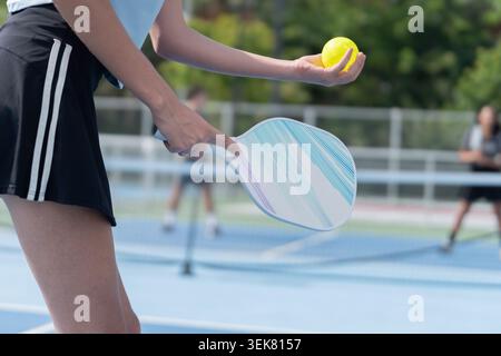 Active Diverse People Playing Pickleball on Outdoor Court Stock Photo