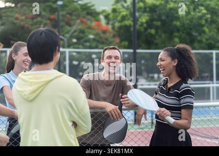 Active Diverse People Playing Pickleball on Outdoor Court Stock Photo