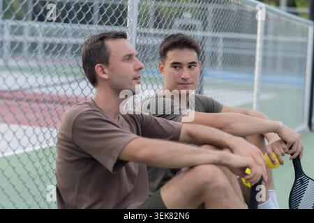 Active Diverse People Playing Pickleball on Outdoor Court Stock Photo