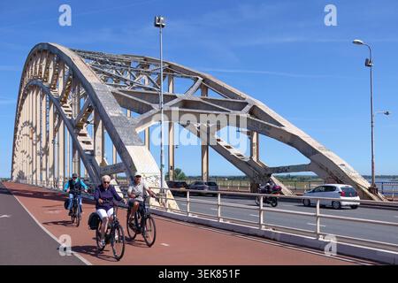 People Cycling on Waal Bridge in Nijmegen Stock Photo