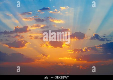 Beautiful sunrise with golden rays of sun breaking through the dark clouds. Stock Photo