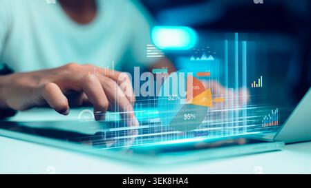 Professional businessman analyzing financial data hologram on laptop with 3D pie charts and graphs. Concept of digital investment, stock market growth Stock Photo