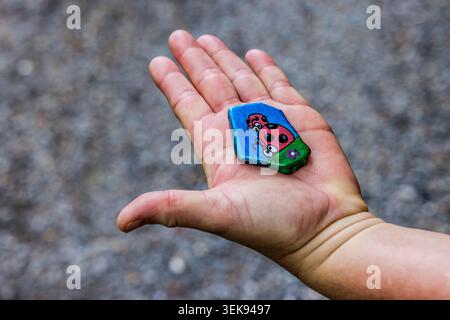 A painted slate stone featuring two ladybirds on a blue background – a so-called ‘Franken-Stein’, which has become a local custom since the start of the pandemic, involving finding, keeping or passing on the stone; Steinbach am Wald, Bavaria, Germany Stock Photo