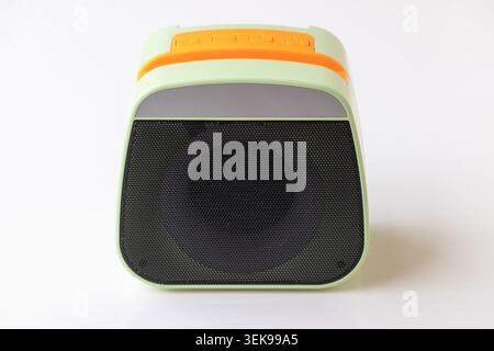 Front view of a small lime-green mini wireless speaker isolated on a plain white surface. Ideal for promoting compact portable audio devices, budget f Stock Photo