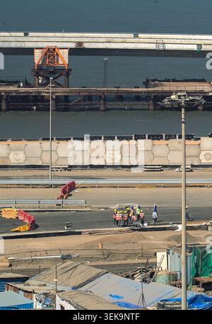 An elevated view showing ongoing construction work on a new coastal road or bridge project in Mumbai, with heavy machinery and materials visible Stock Photo