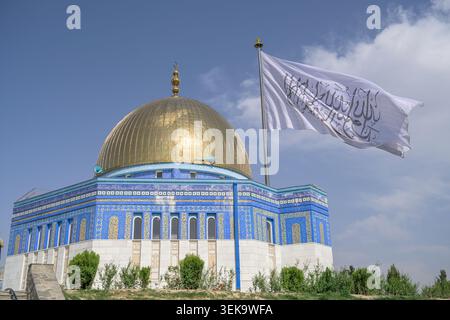 Akbar Khan Hill featuring a golden dome, blue tiles, and the white Taliban flag Stock Photo