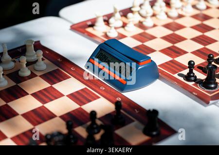 Digital chess clock timer close up on a wooden chessboard background during a match Stock Photo