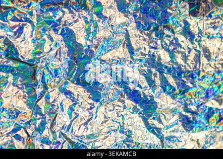 Holographic crumpled foil abstract with iridescent rainbow shine and metallic texture for backgrounds Stock Photo