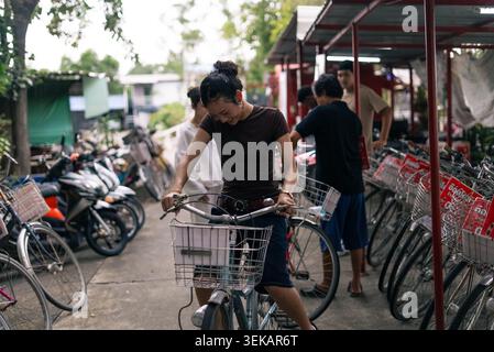 Young woman smiling, preparing to ride bicycle for urban commuting Stock Photo