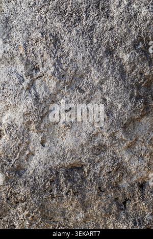 Rough limestone rock wall texture close-up with weathered natural stone surface and detail Stock Photo