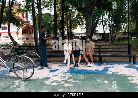 Young student friends interacting outdoors, sharing ideas and enjoying conversation Stock Photo