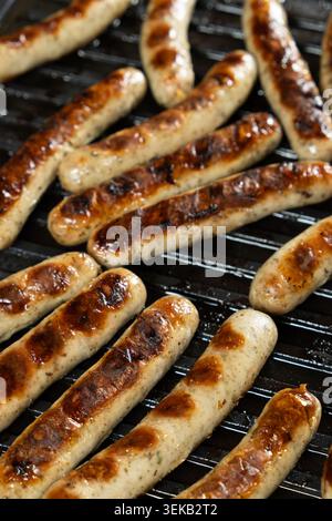 Delicious Pork Sausages Roasting on Contact Grill Surface. Stock Photo
