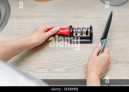 Sharpening a kitchen knife in the home kitchen Stock Photo