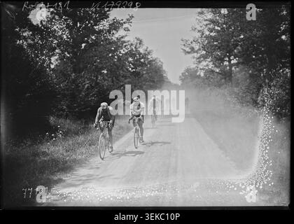 The leading peloton rides before reaching La Guerche-sur-l'Aubois during the first Paris to Moulins stage of the Aiglons cycling race in 1922, advancing along the route in a press photograph from the event. Stock Photo