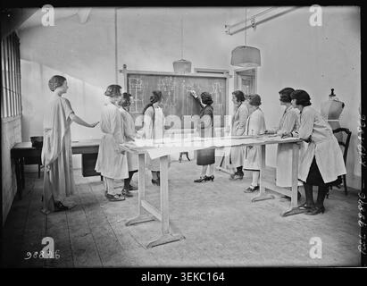 Apprentices attend a pattern making lesson at a fashion school on Rue de Babylone in Paris in 1925. The press photograph records students engaged in couture training and vocational instruction in the 7th district classroom setting. Stock Photo