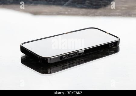 Ukraine, Dnipro, May 31, 2026 - An Apple iPhone 16 smartphone lies on a glass table outside Stock Photo
