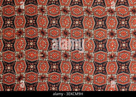 Detailed red and black geometric textile pattern with ethnic star and floral motifs. Repeating decorative vintage Uzbek block-printed fabric texture Stock Photo