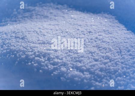 Beautiful close-up of sparkling snow with a shallow depth of field creating a soft, dreamy bokeh effect. Perfect winter or holiday concept background. Stock Photo